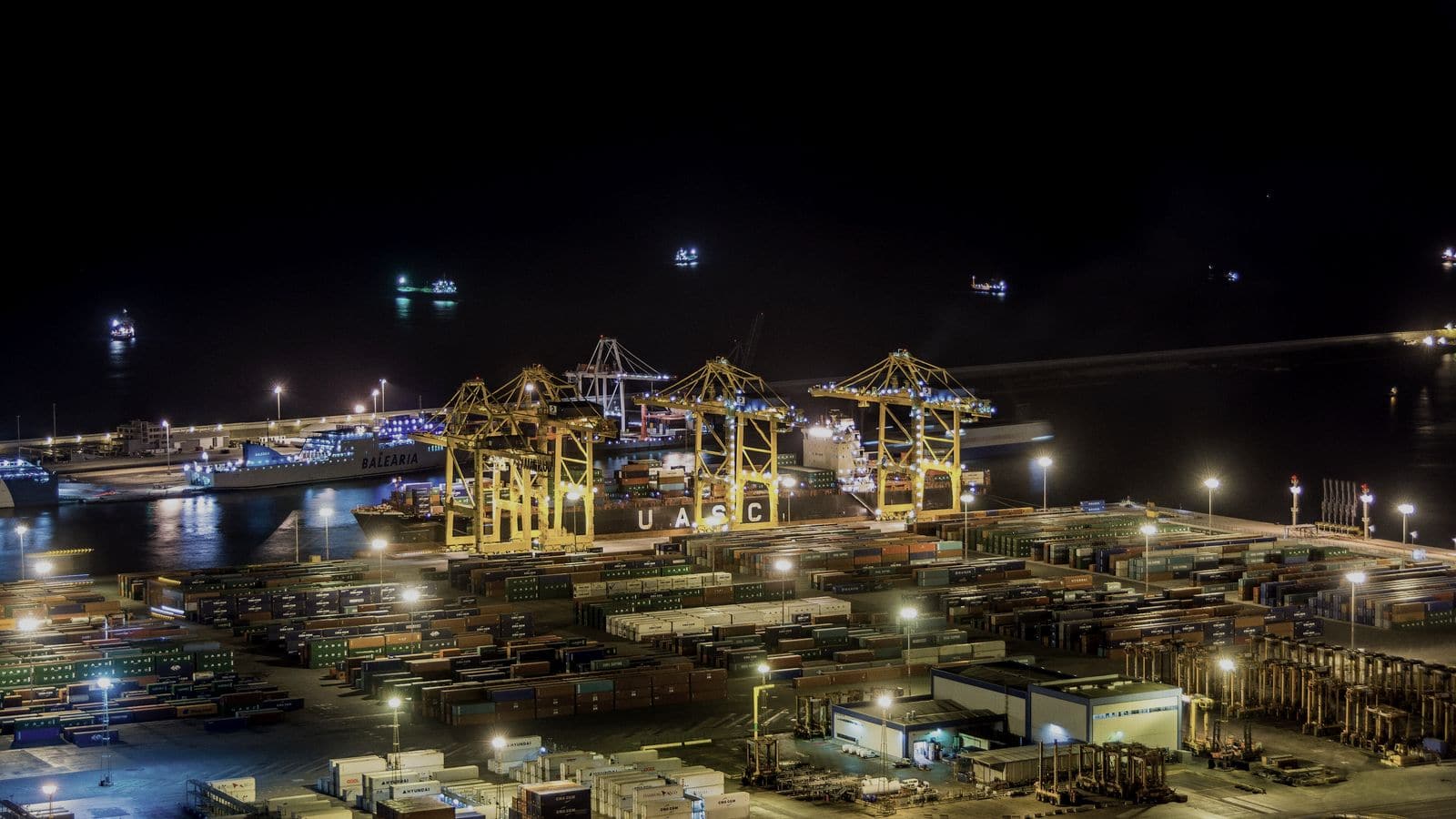Ship-to-shore cranes working a container vessel at night
